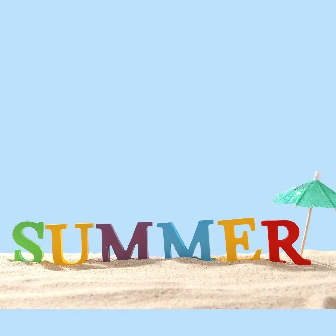 Bunte Buchstaben, die das Wort "SUMMER" im Sand formen, mit einem kleinen Sonnenschirm daneben – Sommerstimmung und Urlaubsfeeling.