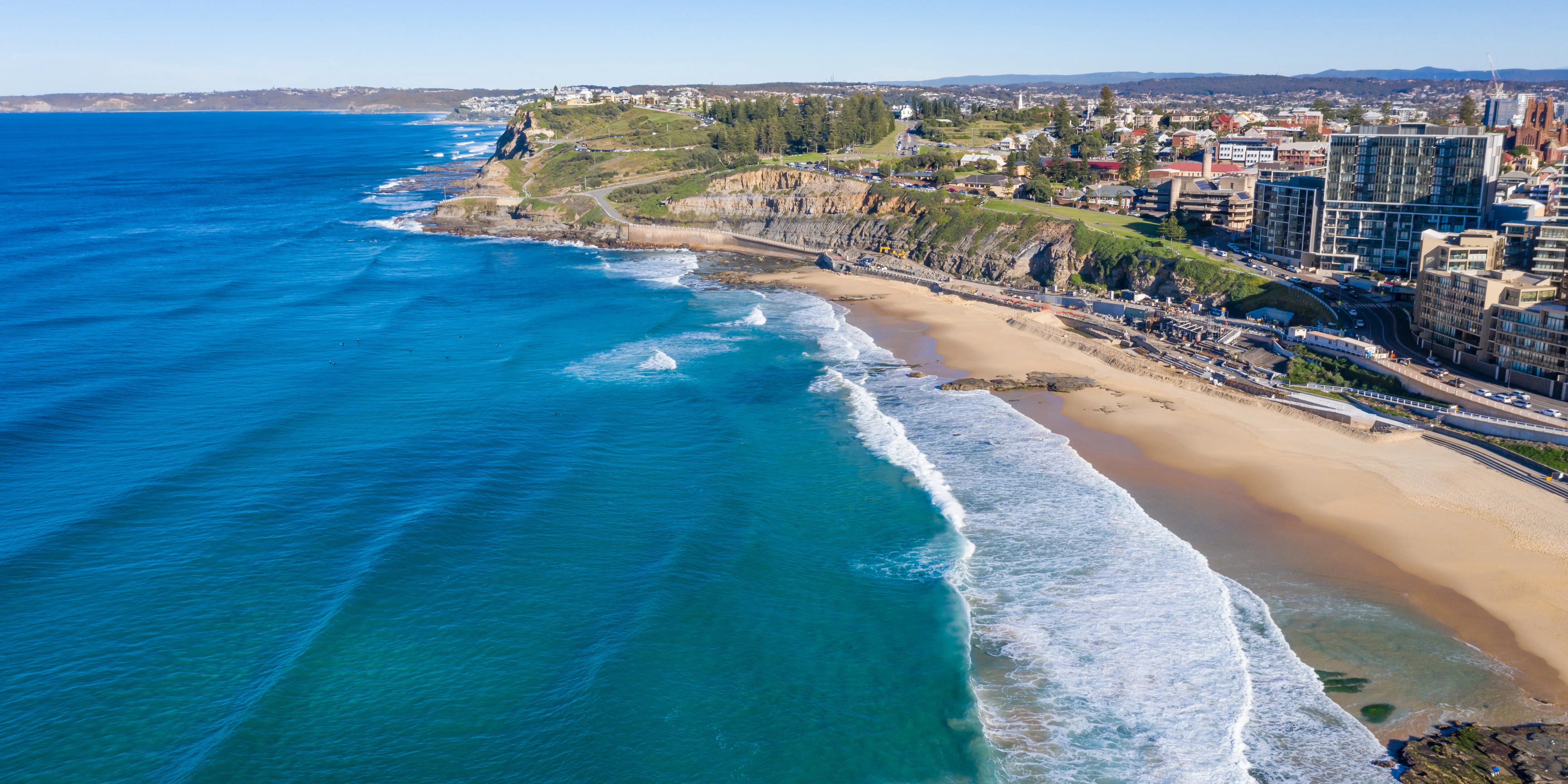 Die Küste der australischen Stadt, Newcastle, abgebildet vom Meer, Strand, Grünflächen, Gebäude und Straßen