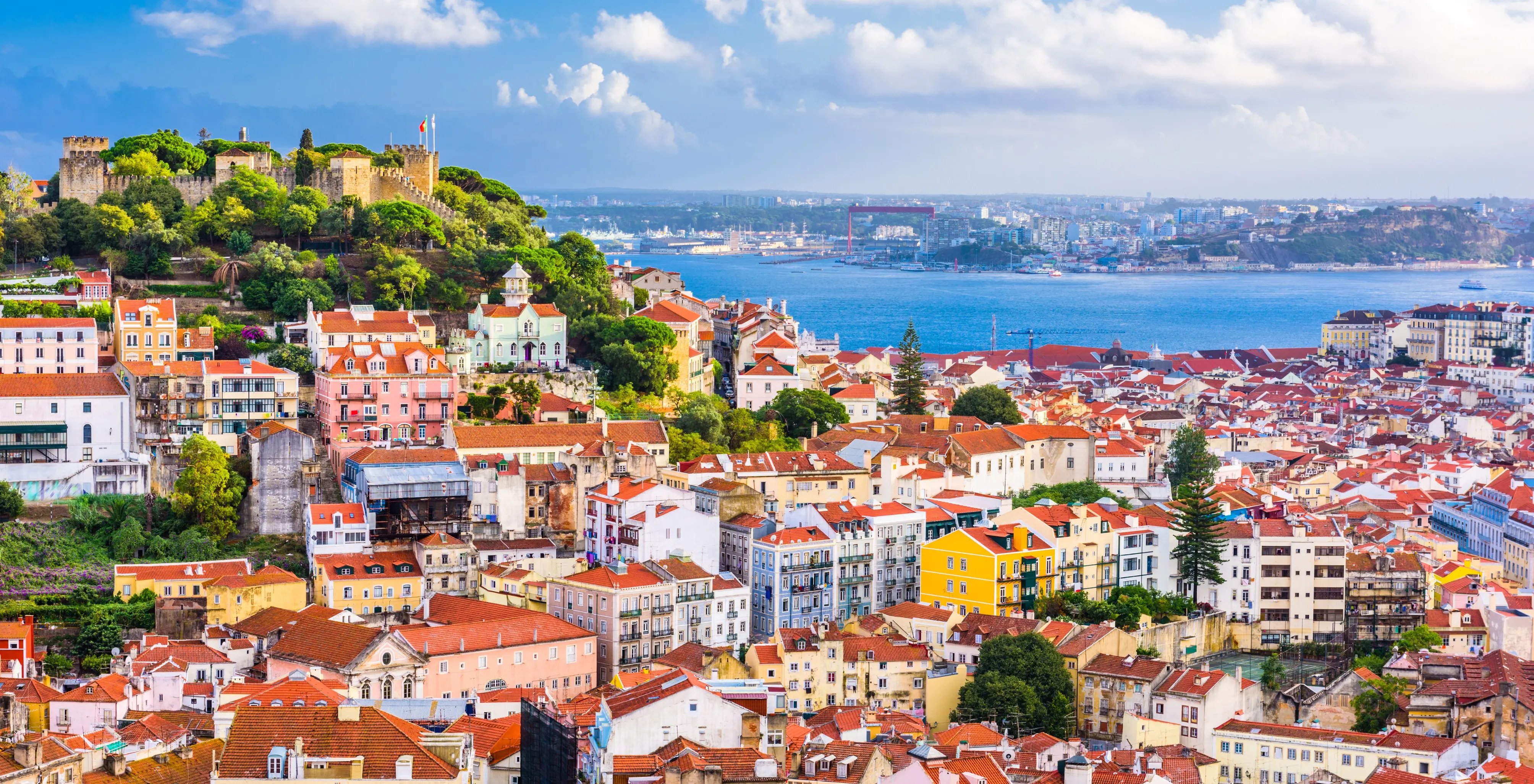 Skyline von Lissabon mit ikonischen Häusern und dem Meer.